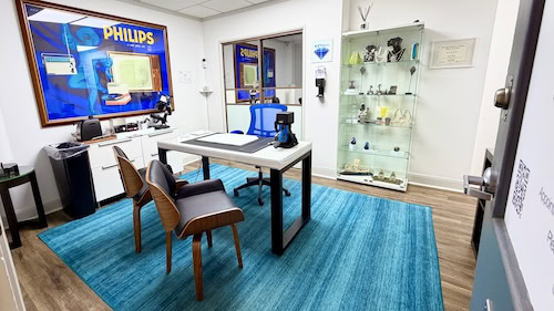 A professional jewelry appraisal room with display case, magnifying tools, and computer for precise evaluation and buying or selling jewelry. By appointment only.