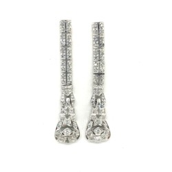 These stunning diamond drop earrings feature an intricate Art Deco design with sparkling diamonds set in platinum, perfect for adding a touch of vintage glamour to any formal outfit. Earrings