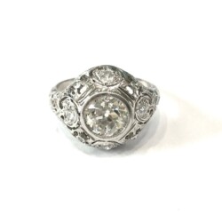 Elegant diamond cocktail ring featuring a large central stone surrounded by smaller diamonds, set in a detailed silver band. Perfect for special occasions or as a statement jewelry piece. Rings