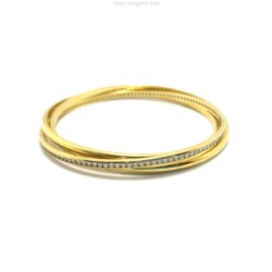 A close-up of a gold and diamond bangle bracelet, showcasing fine craftsmanship and luxurious design, perfect for jewelry enthusiasts and collectors. Bracelets