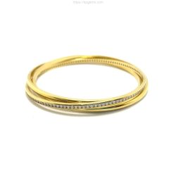A close-up of a gold and diamond bangle bracelet, showcasing fine craftsmanship and luxurious design, perfect for jewelry enthusiasts and collectors. Bracelets